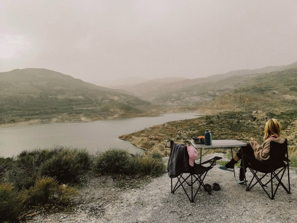 a couple of people sitting at a table on top of a hill